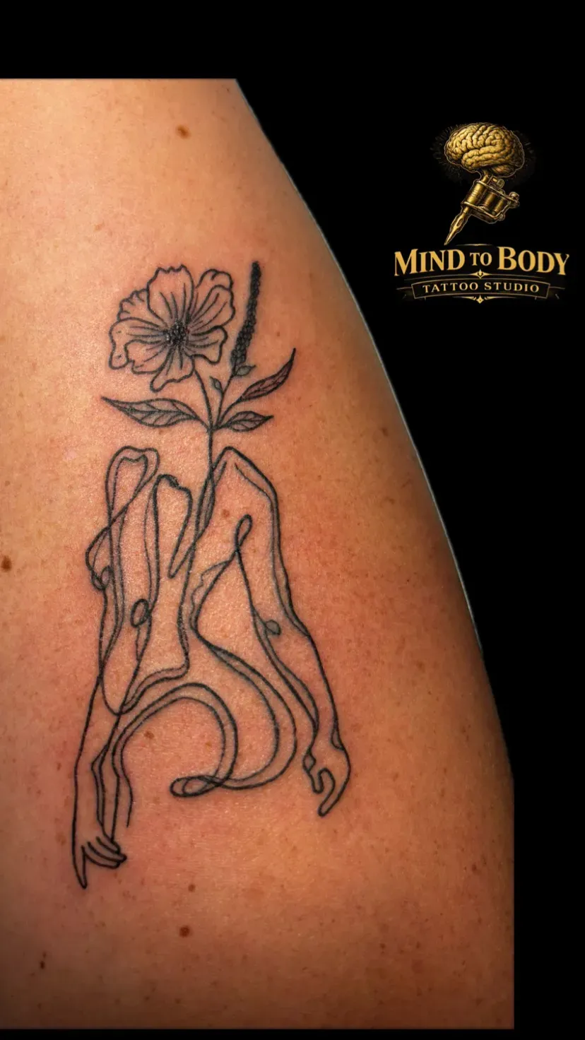 Fine line klaproos met vrouwfiguur in doorlopende lijn op het bovenbeen, tattoo Gent