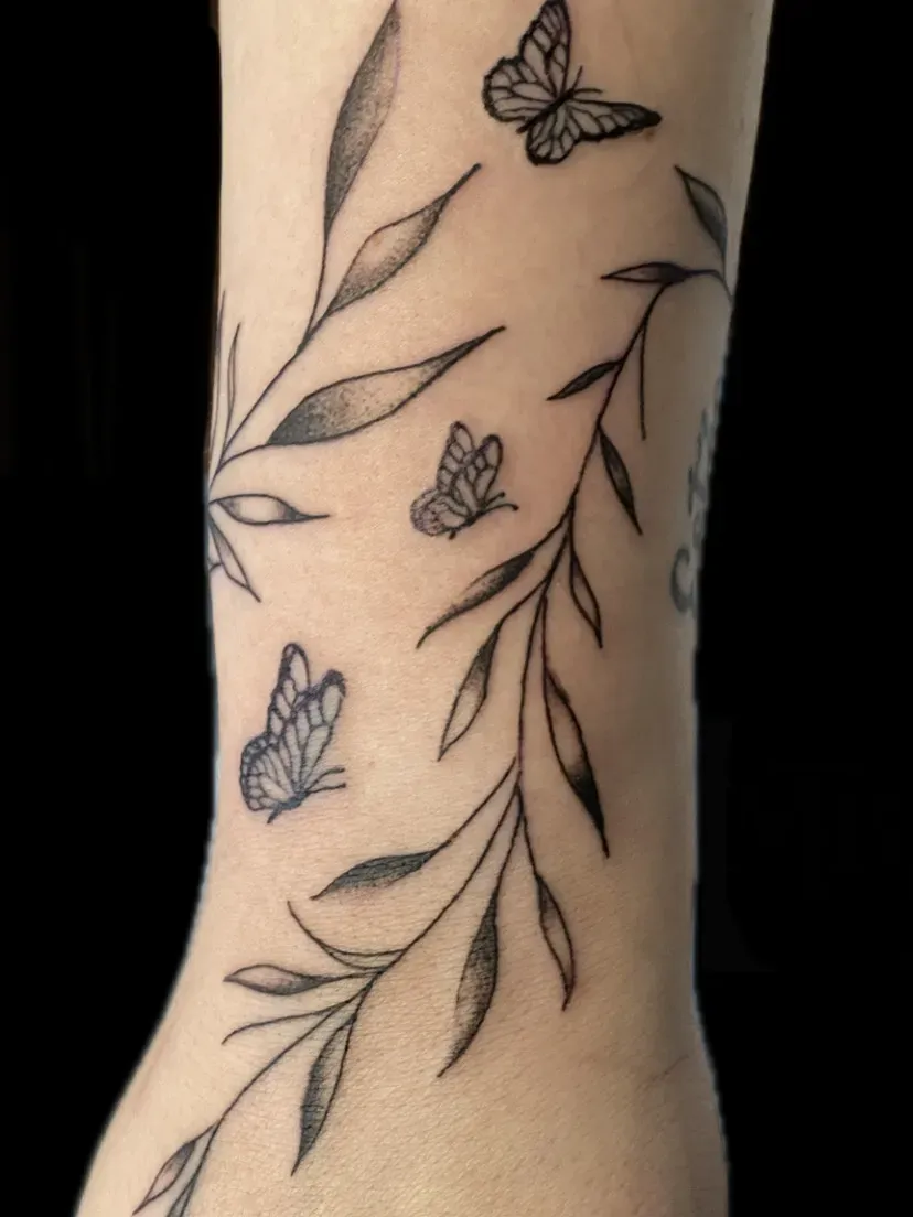 Fine line bladtak met vlinders rond de onderarm, tattoo Gent