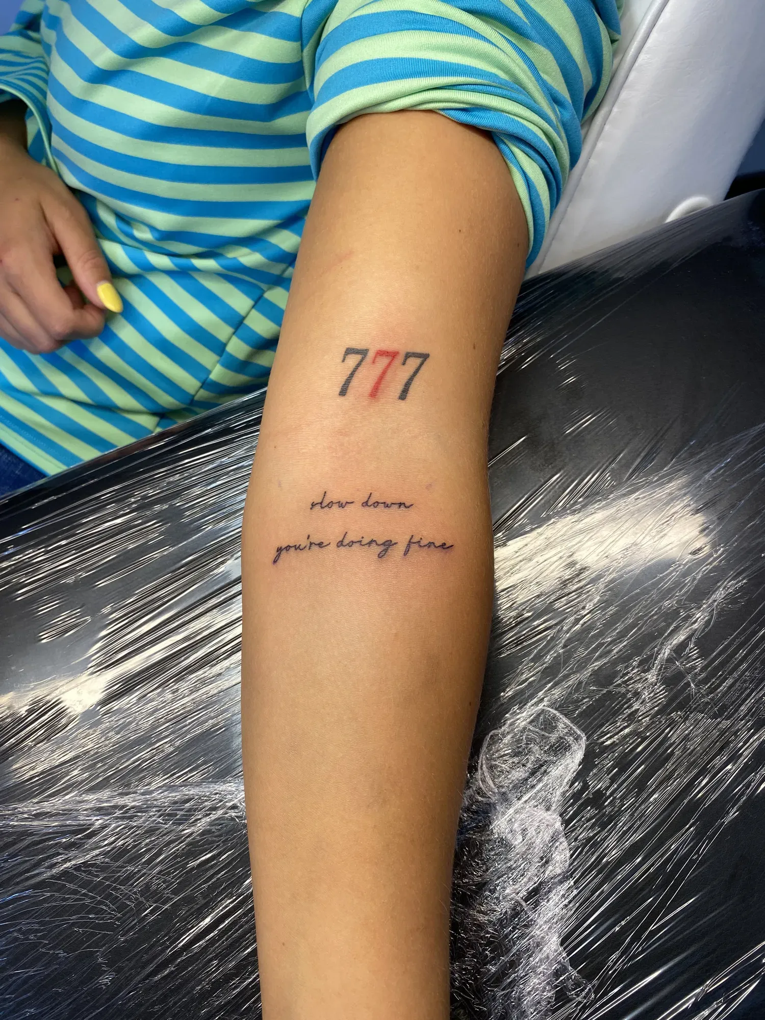 Lettering 777 met sierschrift op de arm, tattoo Gent